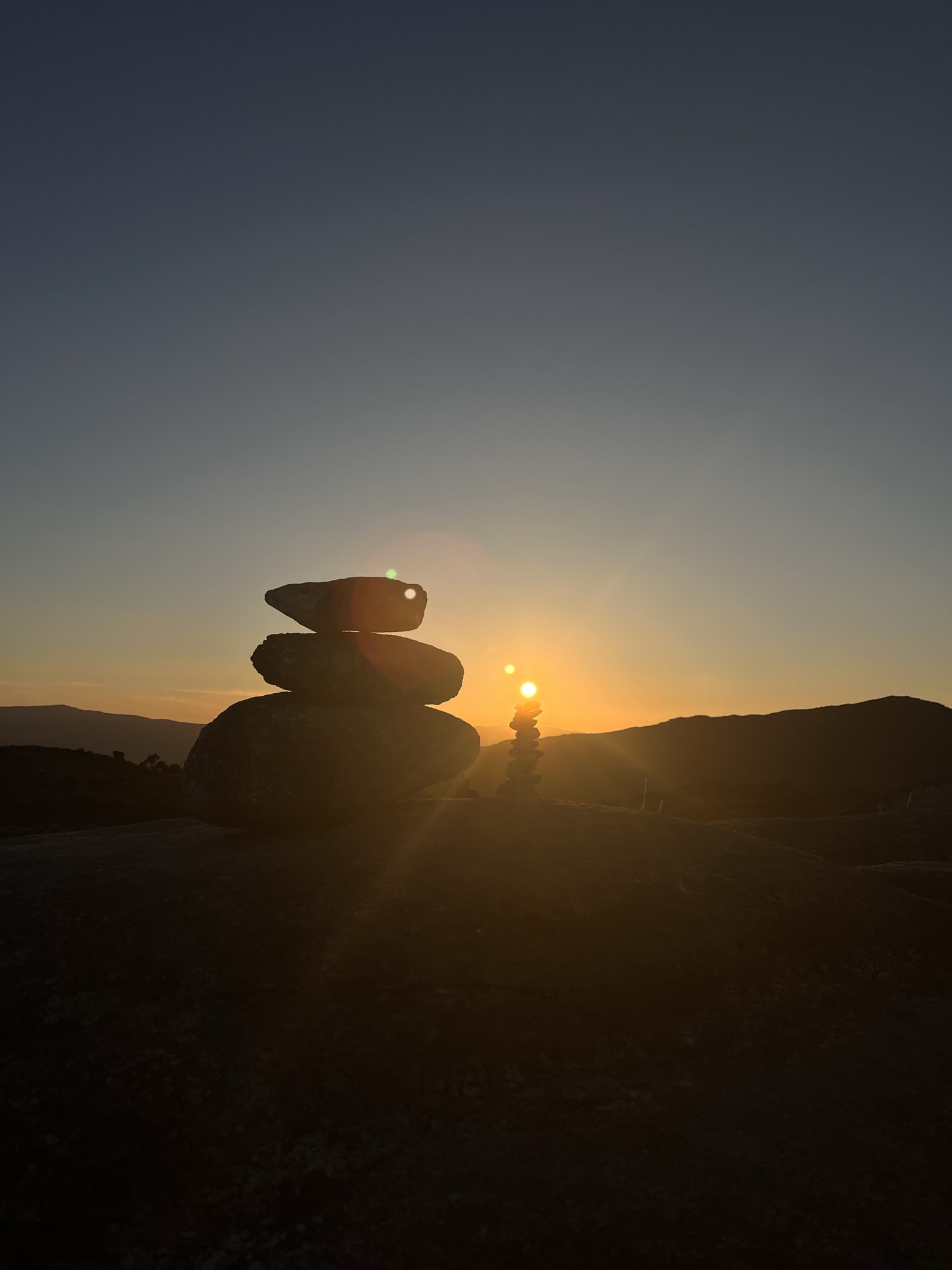 Pôr do sol com pedras empilhadas