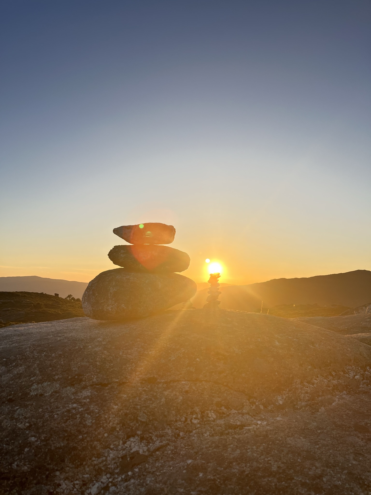 Pôr do sol com pedras empilhadas